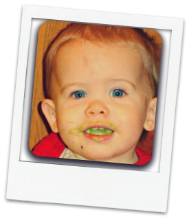 Baby with messy face enjoying quinoa